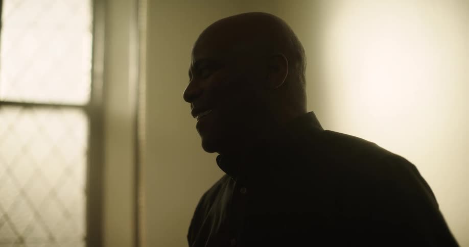 A man smiles in the dark room