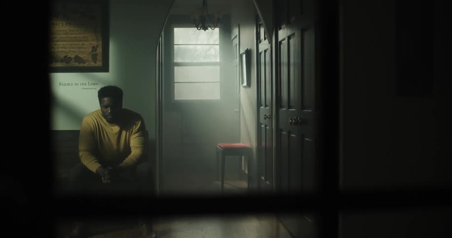 A man is sitting in a dark hall