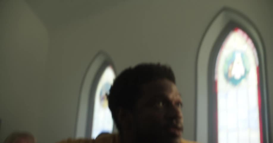 A man walks in to a church service and sits down in the pew