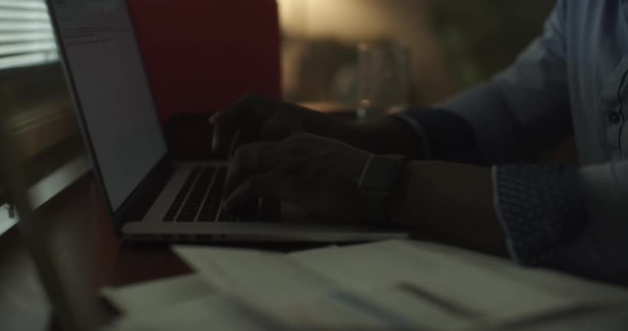 A person sitting at a desk typing on a laptop