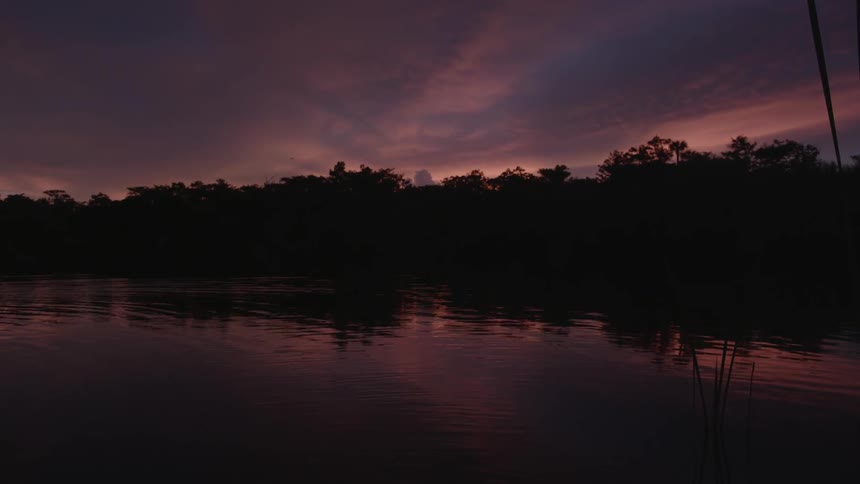 Calm waters on a lake can be seen as the sun sets