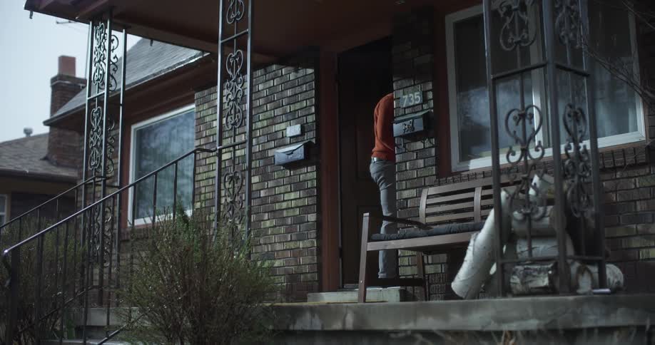 A man is walking inside of his house