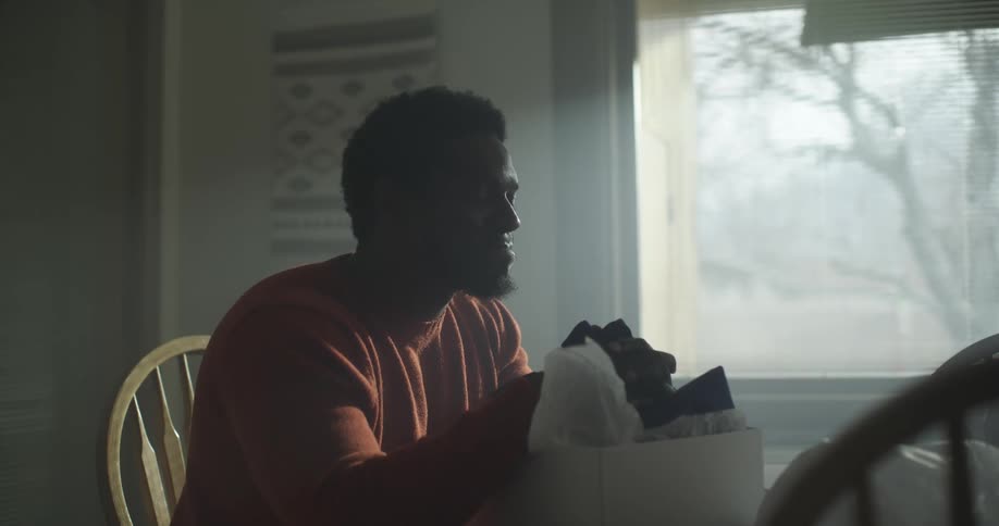 A man looks at a gift and smiles
