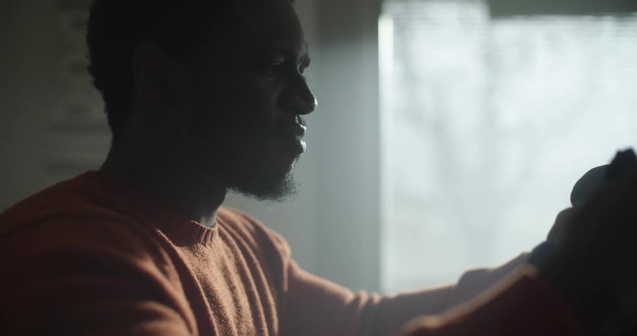A man unwraps a gift and laughs and smiles