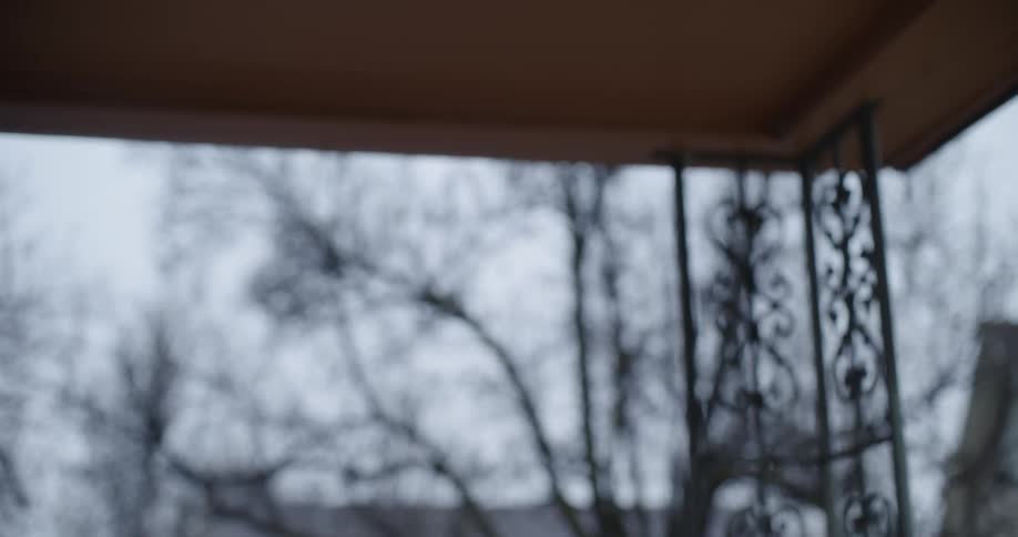 A black man walks up to a porch and bends over