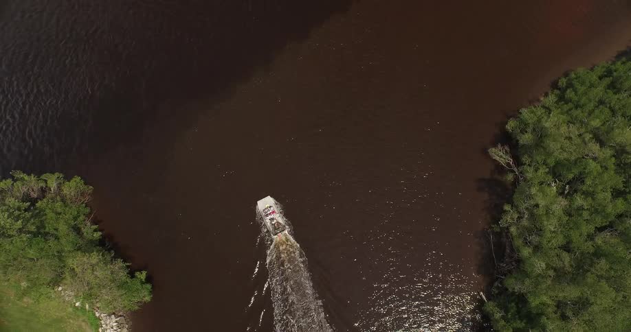 A boat travels down a muddy looking river