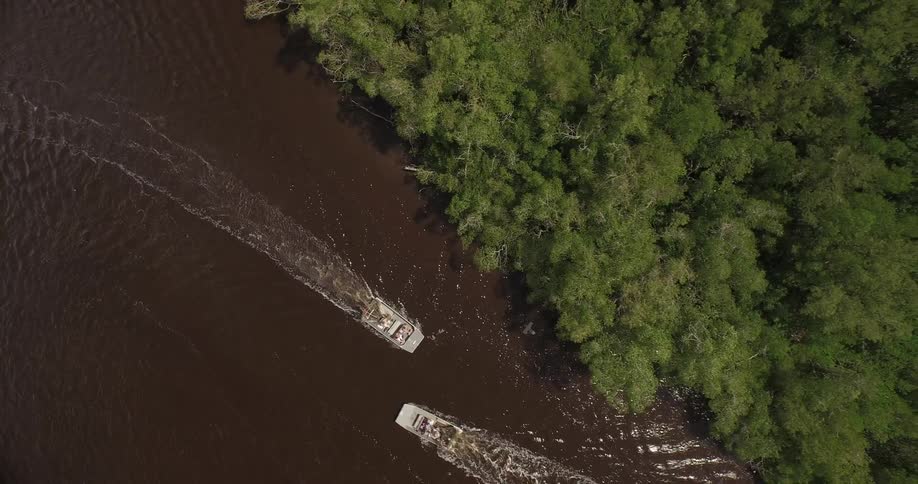 Two boats pass in a river in the daytime