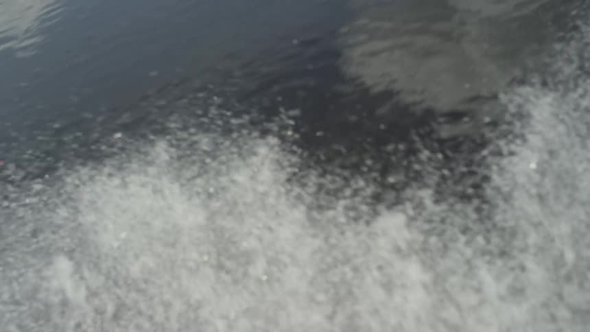A boat churns up water on a river