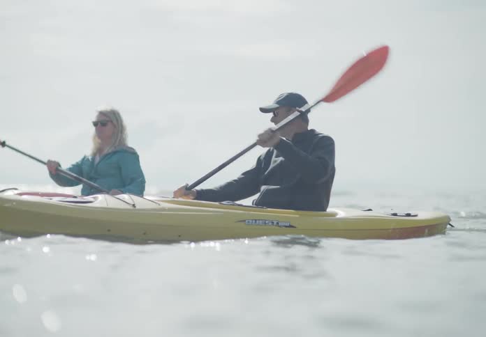 A man and a woman kayaking in a lake