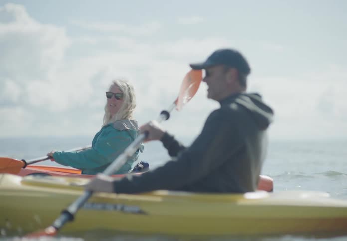 A man and a woman in a lake kayaking