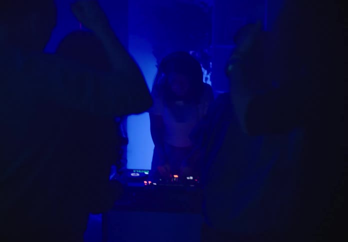 A group of people are dancing in a venue at night