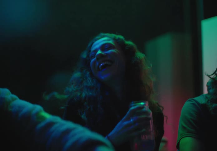 People sitting down drinking and talking in a party
