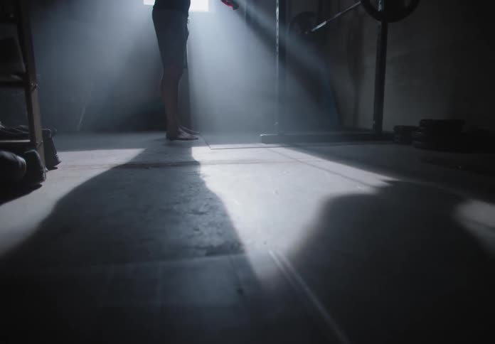A man adjusts a strap in a weight room