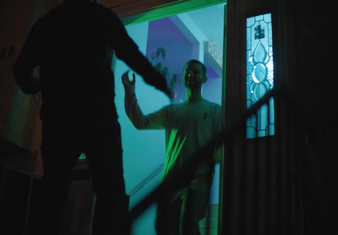 A man goes to a house and meets up with a friend