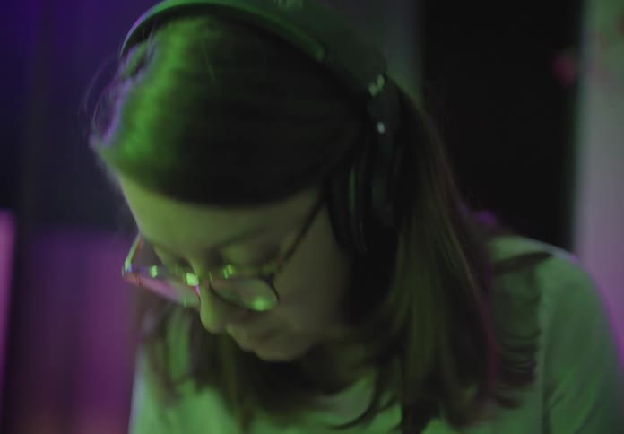 A woman with headphones djing a party