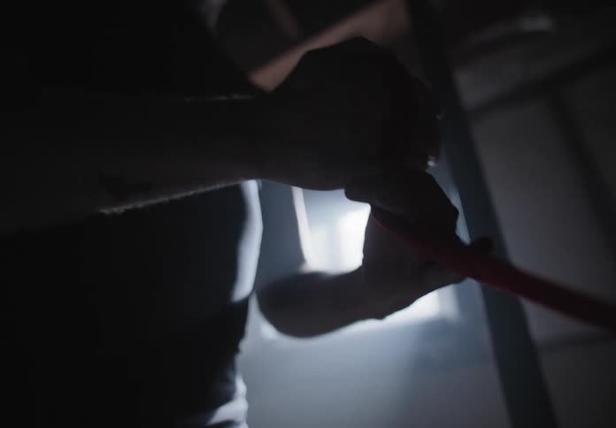 A white man wraps his hand in cloth while in a basement