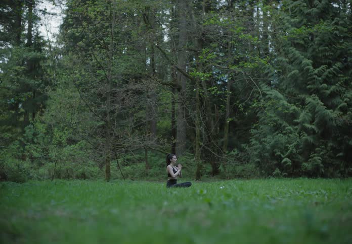 The woman does yoga on the grass