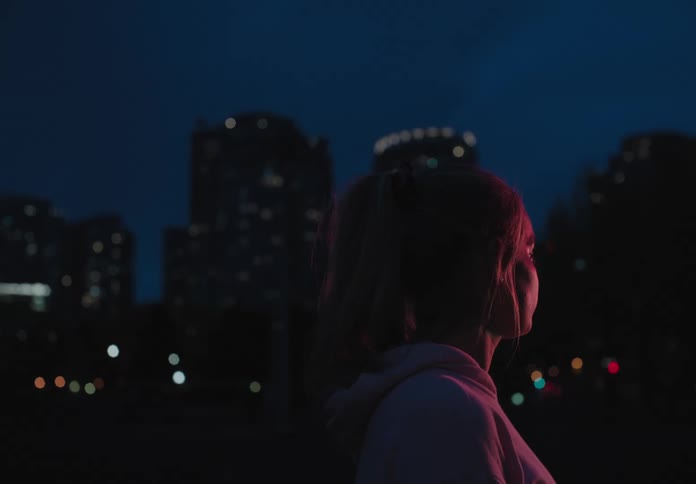 A woman is standing outdoors at night