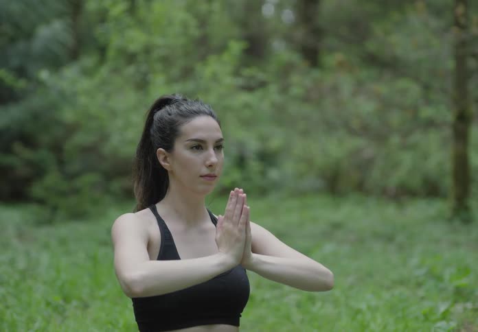 A woman sitting on grass stretching