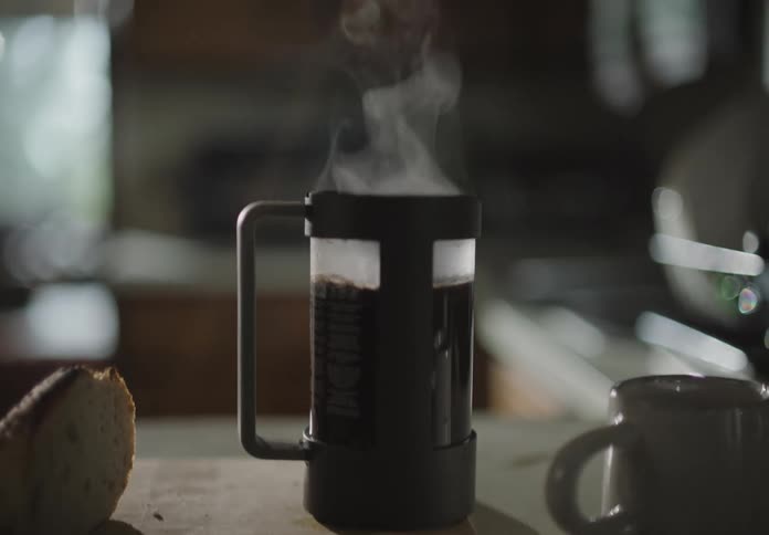 A cup filled with a hot beverage sits on a kitchen counter top
