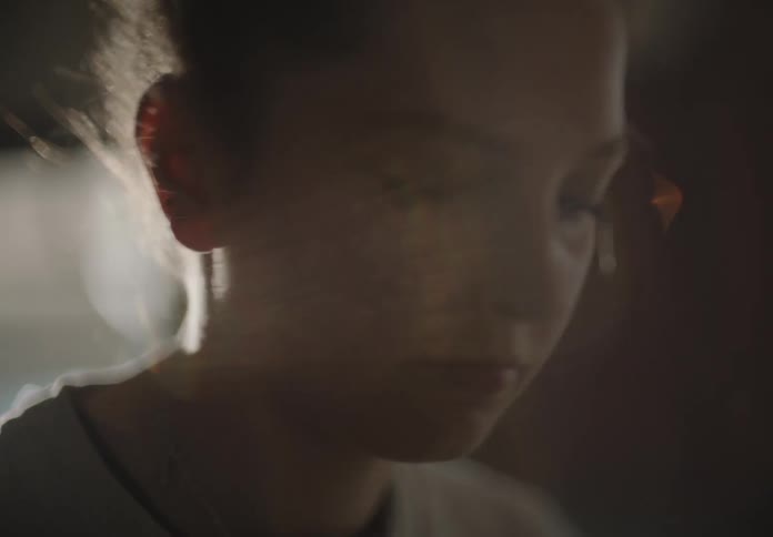 A woman looking around with sunlight in the background