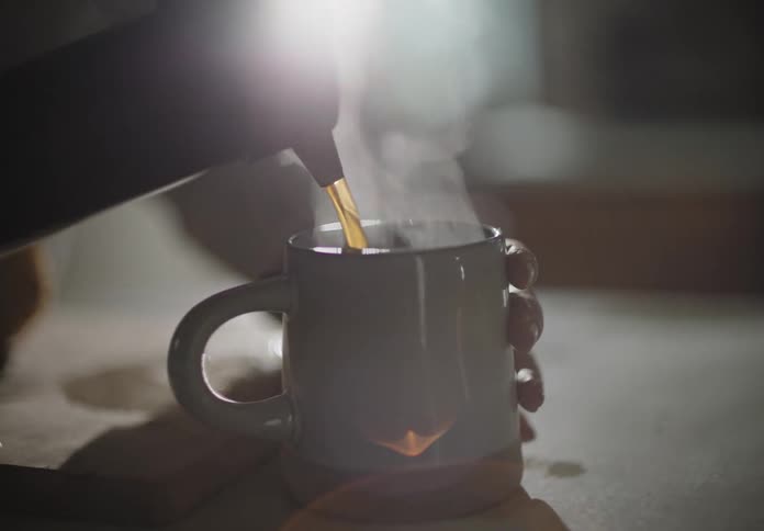 A woman pouring coffee into a cup