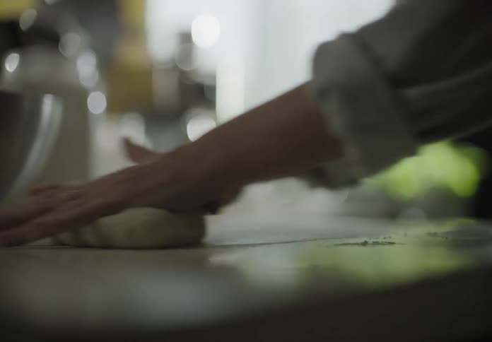 A woman kneading dough on a table