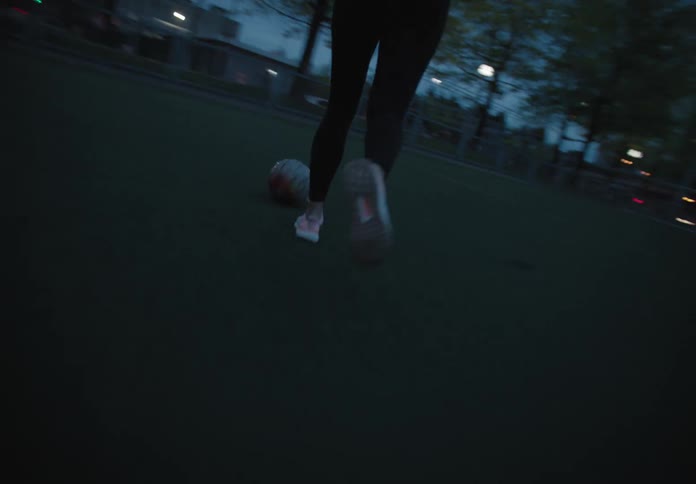 A teenager kicks a soccer ball on a field