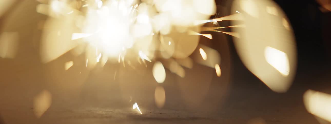 Sparks from a sparkler flying and shining at night
