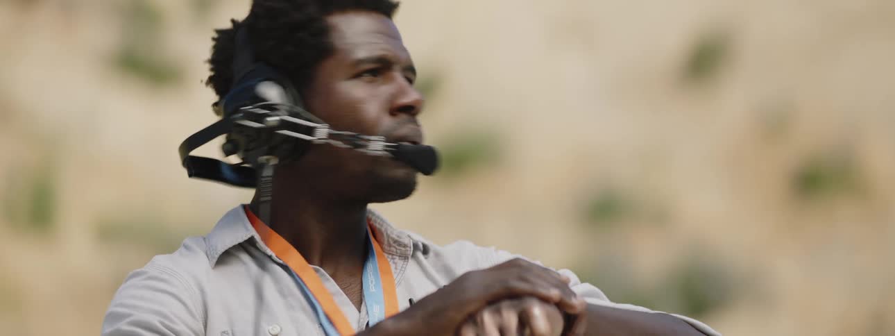 A man with a headset on looking at his watch