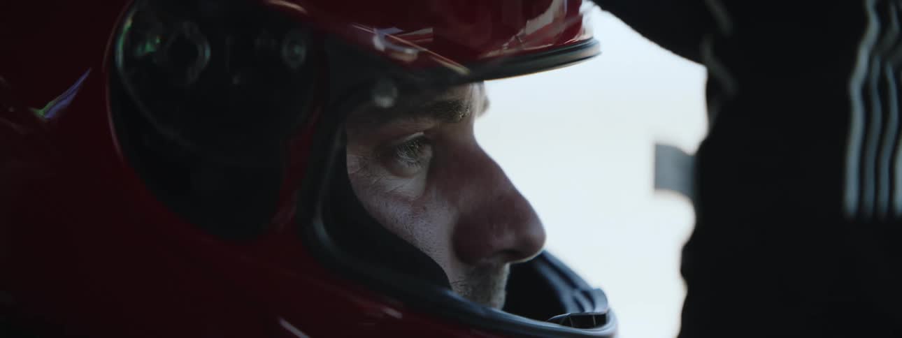 Man wearing red crash helmet and gloves opens and closes face plate