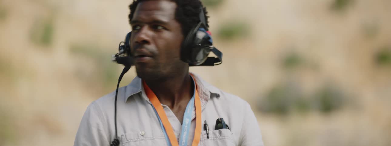 A man wearing a headset is standing outdoors