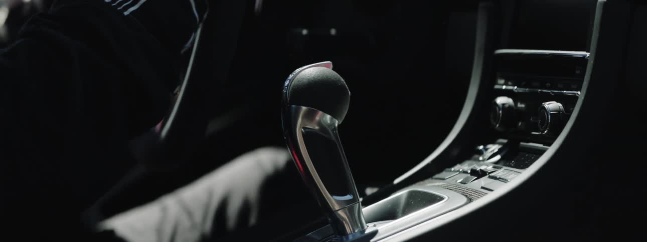 Person wearing racing gloves drives aggressively shifting gears
