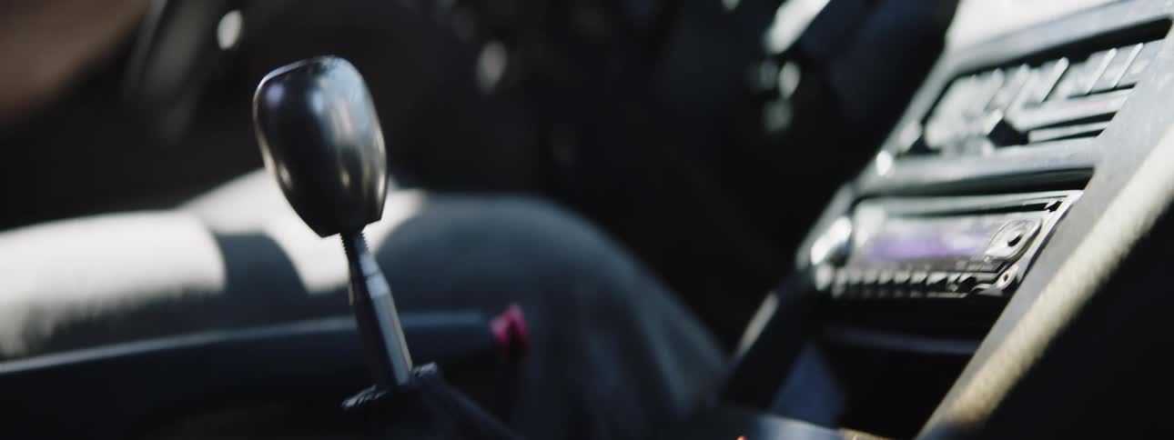 A person driving a car shifting gears
