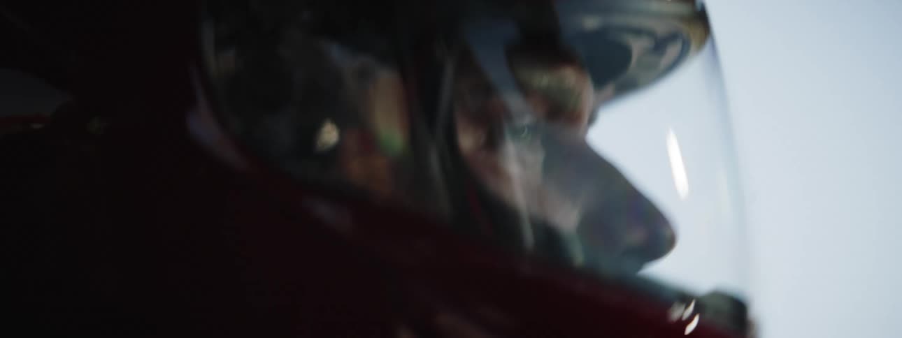 A man in a helmet driving a car