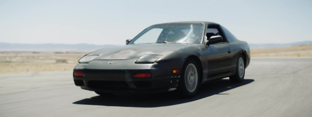 A sports car travels a desert road