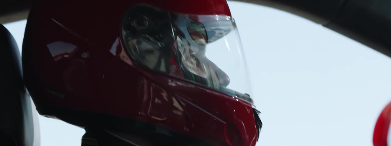 A man wearing helmet drives a car