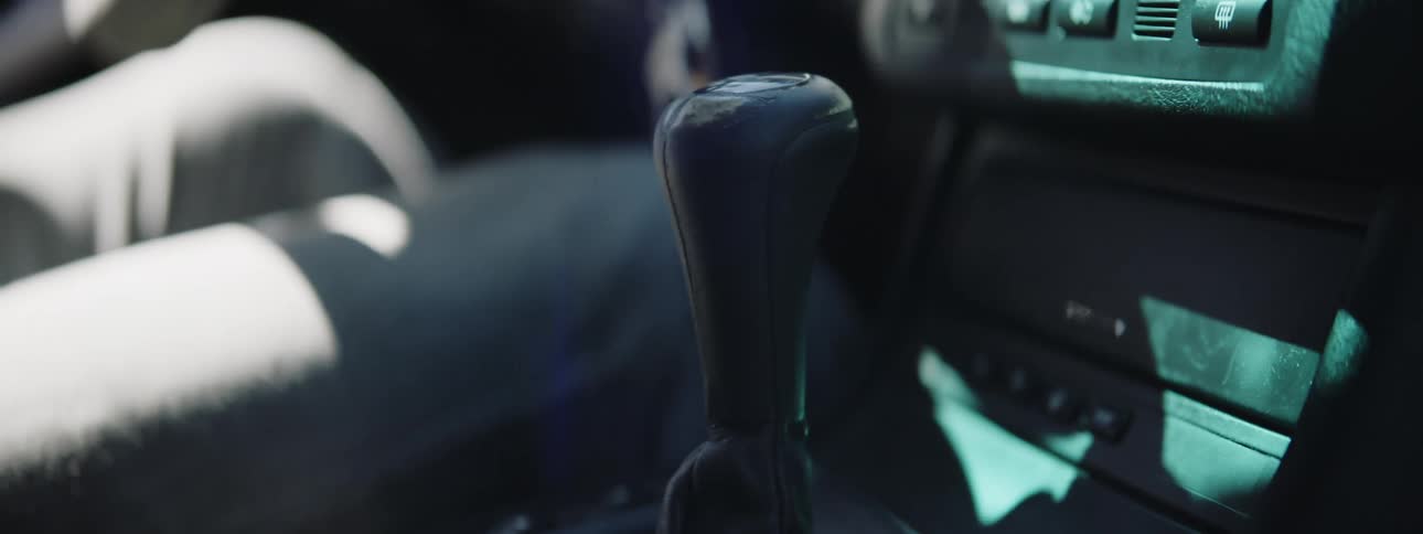 A man shifting gears as he races a car