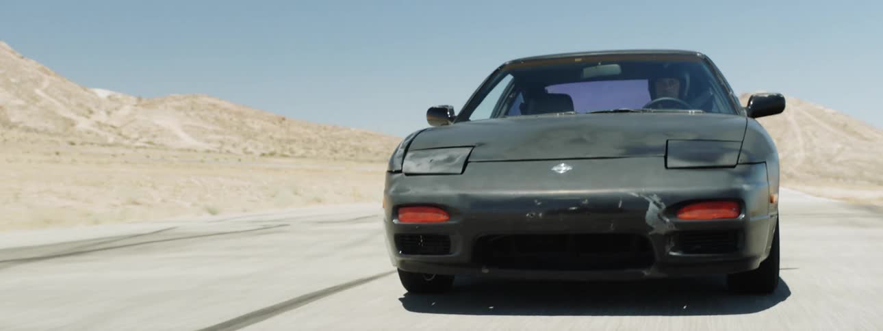 A person driving a car with the sky in the background