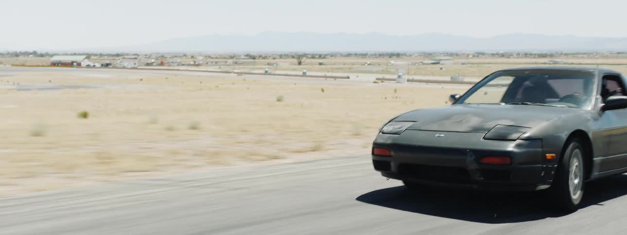 A man is driving a car in a desert area