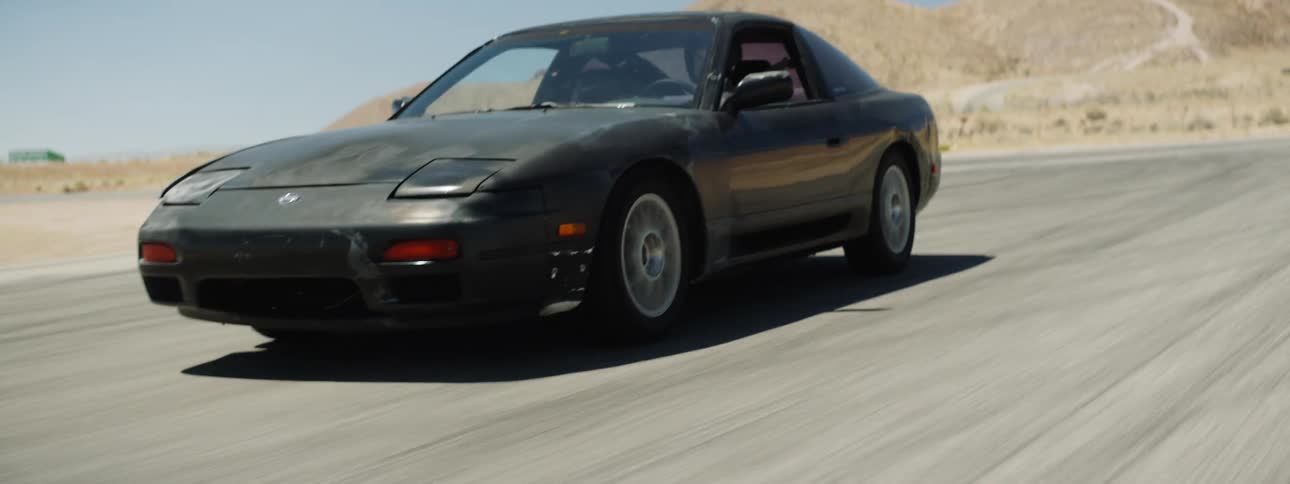 A car races on the track in the desert on a sunny day