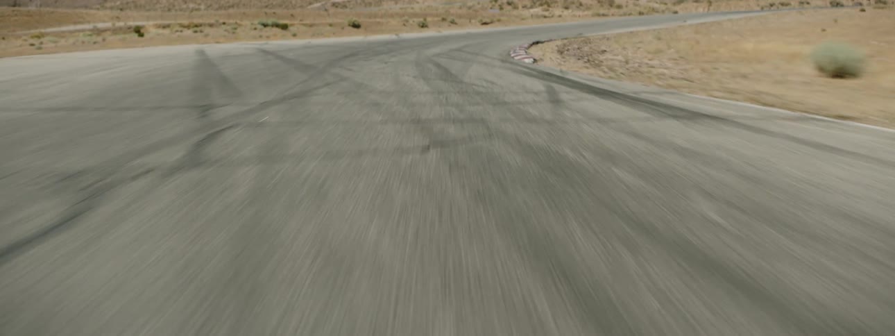 A curving road marked with tire tracks in the desert