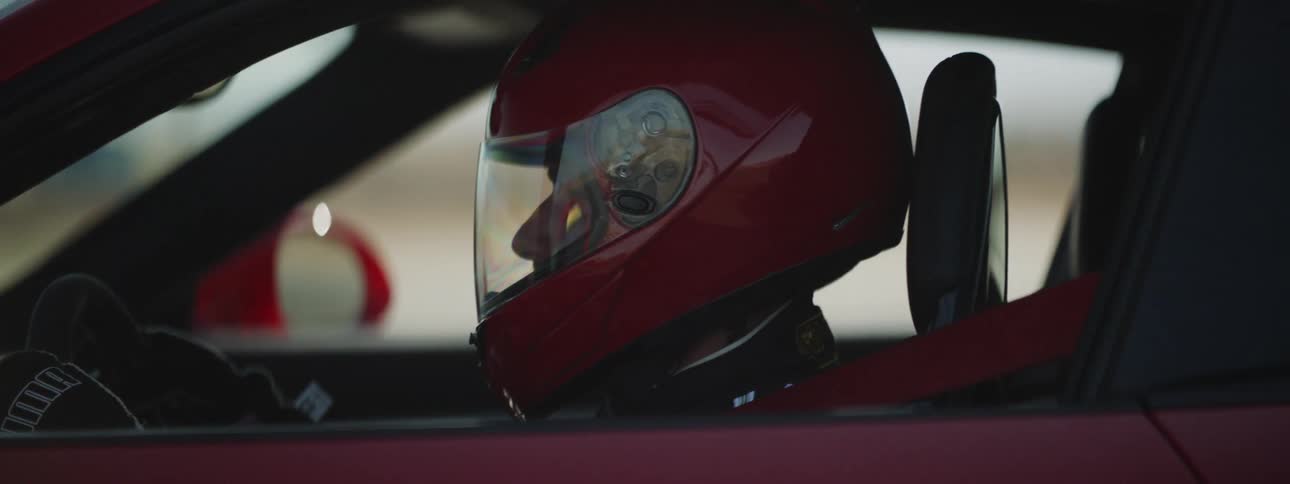 A person in a red helmet inside a red sports car