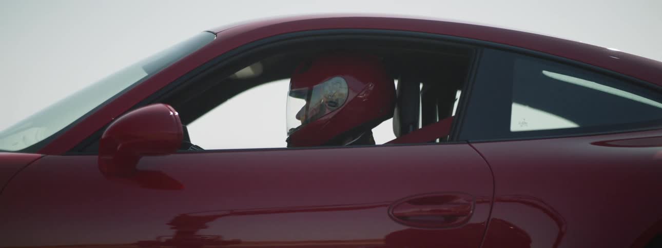 A man sits in the vehicle wearing a helmet