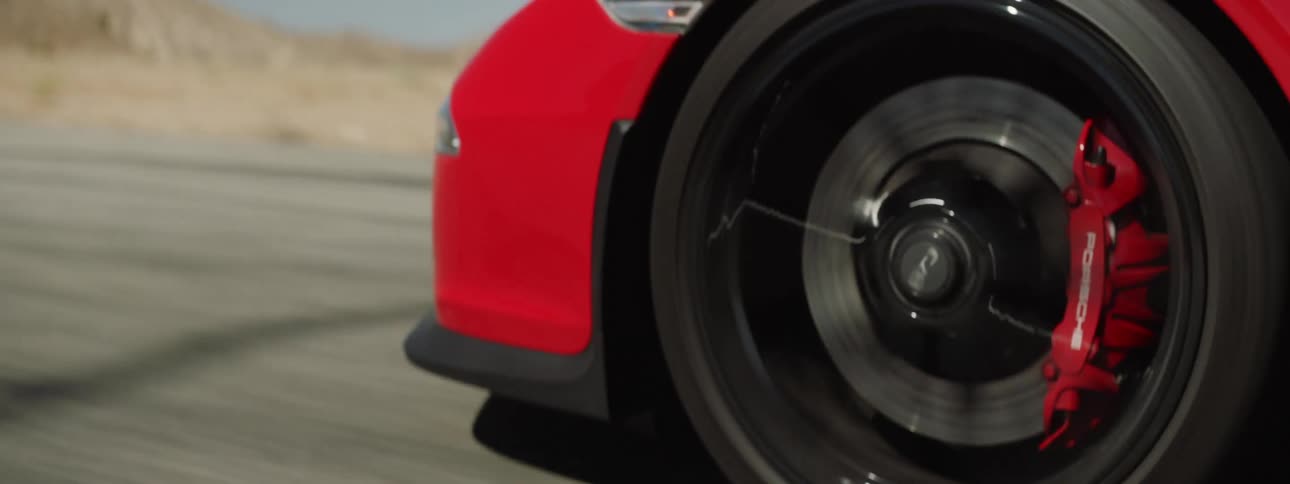 A sports car speeds down a deserted road