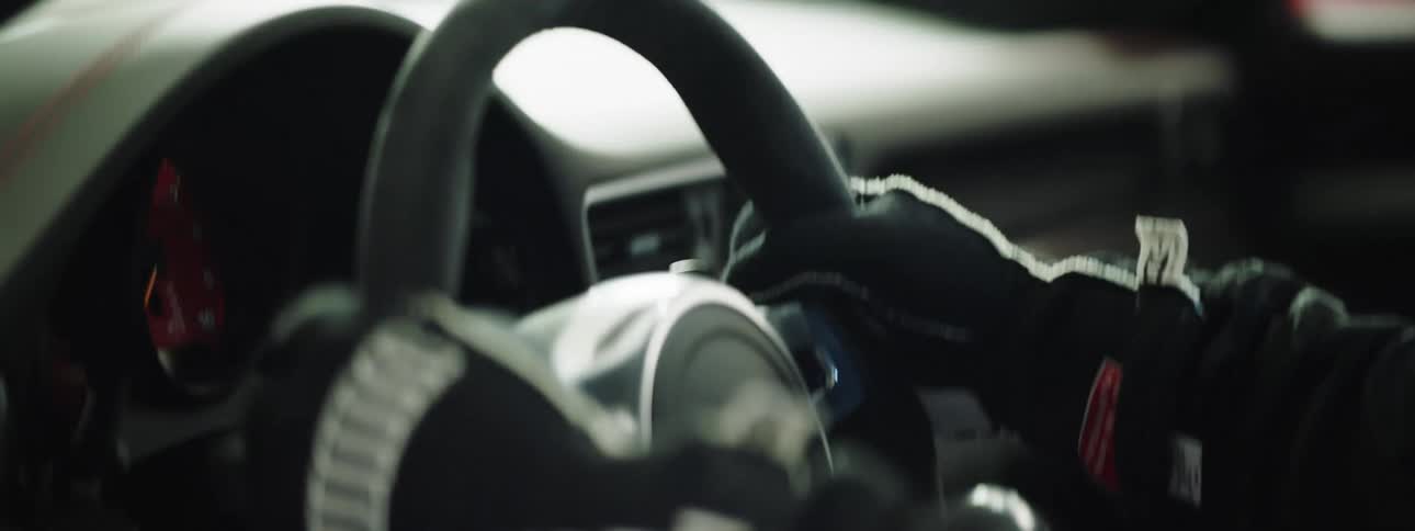 A person grabs the steering wheel as they prepare to race