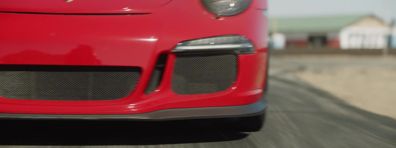 A sports car making a turn on a track in the desert