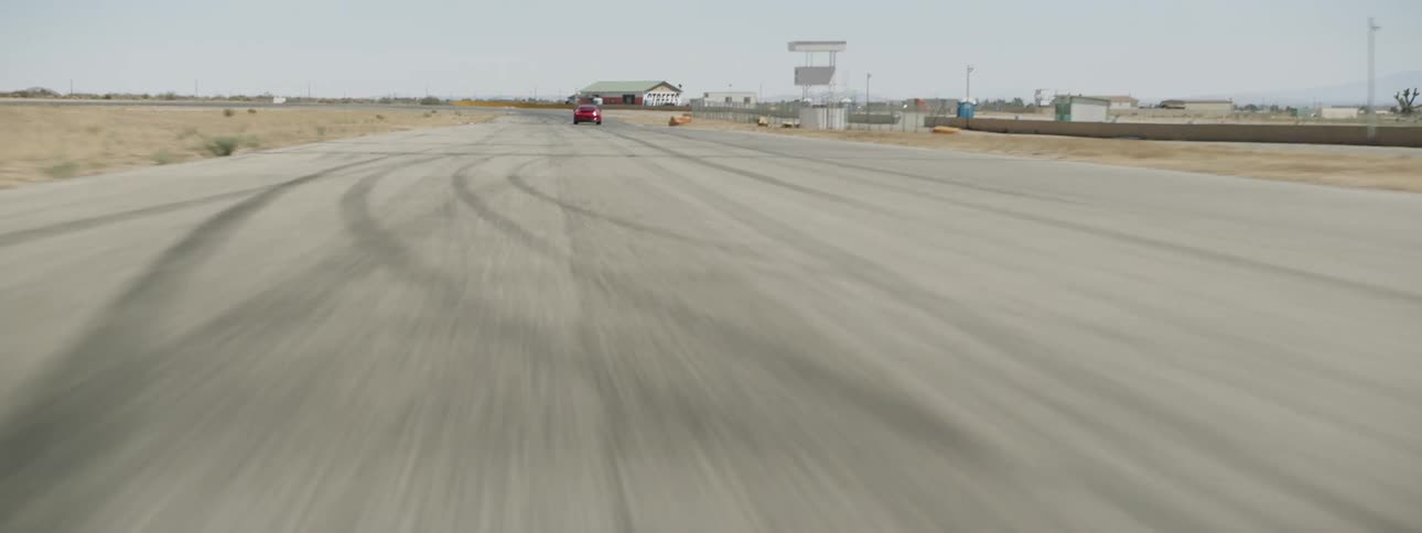 A sports car speeding down a race track in the desert