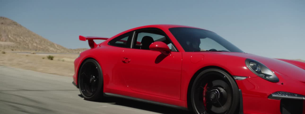 A sports car speeds down a deserted road