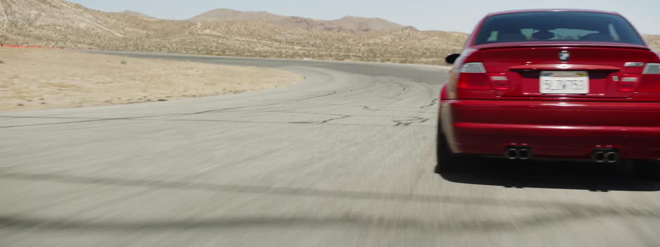 The red car races on the road in the desert